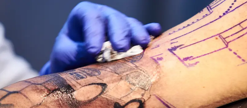 Tatuador limpiando un tatuaje